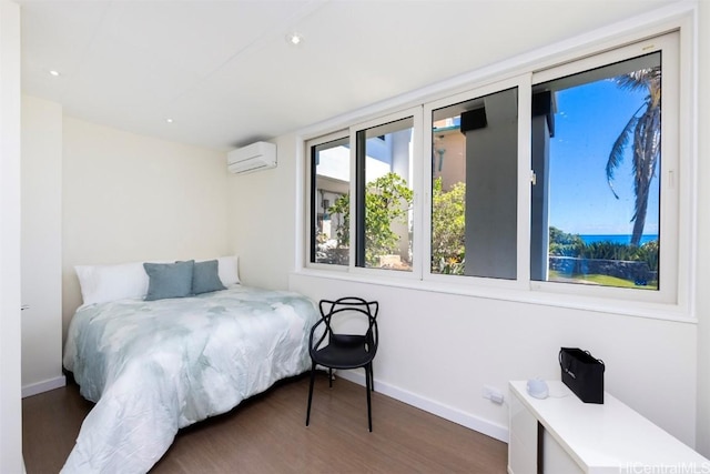 bedroom with a wall unit AC and dark wood-type flooring