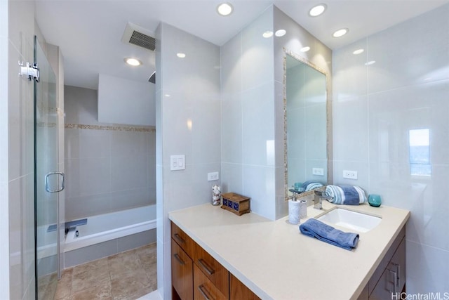 bathroom featuring vanity, separate shower and tub, and tile walls