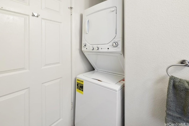 clothes washing area featuring stacked washer / dryer