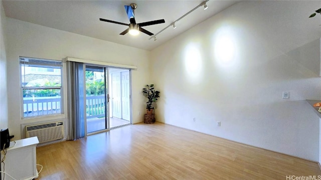 unfurnished room featuring a wall mounted air conditioner, ceiling fan, light hardwood / wood-style floors, and lofted ceiling