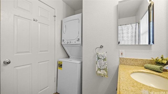 bathroom featuring stacked washer / dryer and vanity