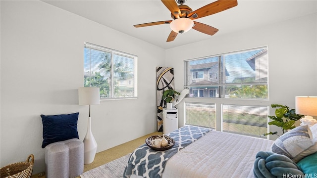 bedroom featuring ceiling fan and light carpet