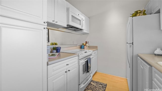 kitchen with white appliances, light wood-type flooring, and white cabinetry