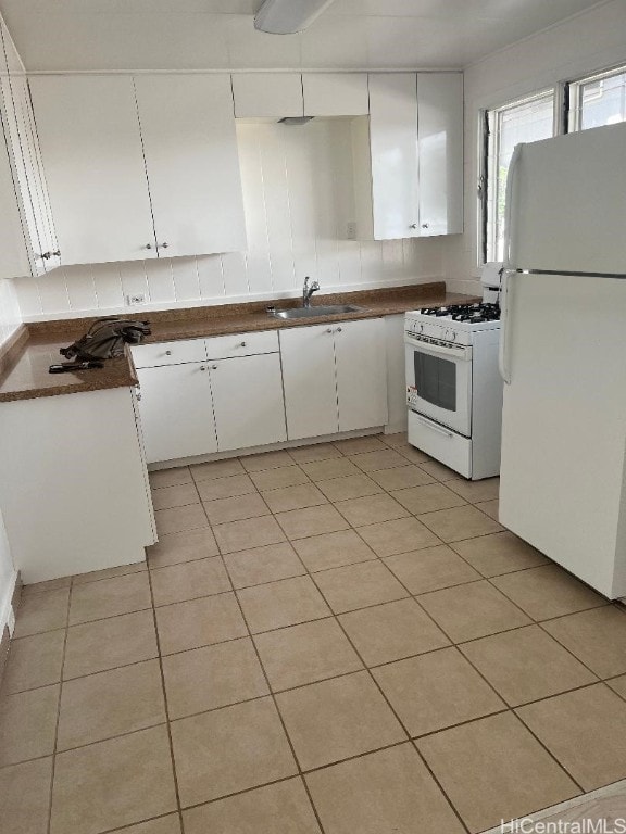 kitchen with backsplash, sink, white cabinets, and white appliances