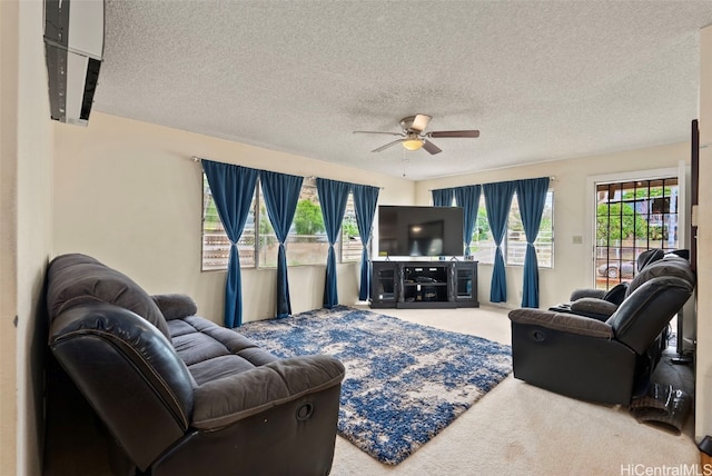 living room featuring carpet flooring, ceiling fan, and a textured ceiling