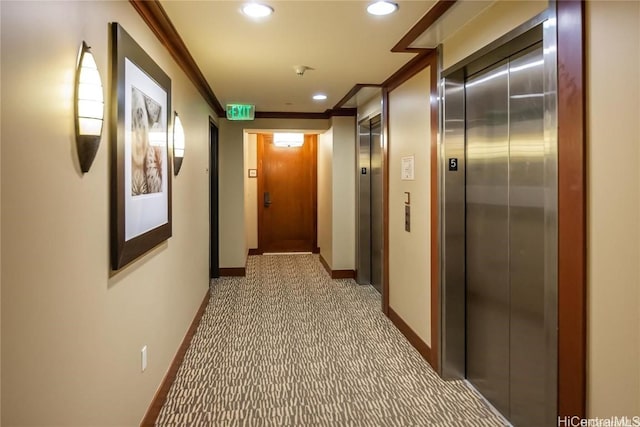 hallway featuring carpet floors, elevator, and crown molding