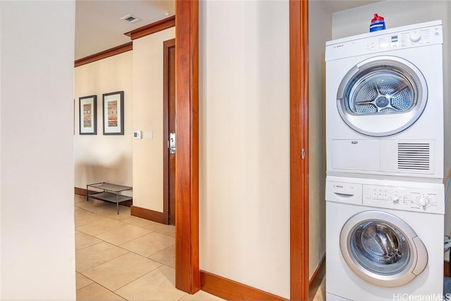 washroom with light tile patterned floors and stacked washer and dryer