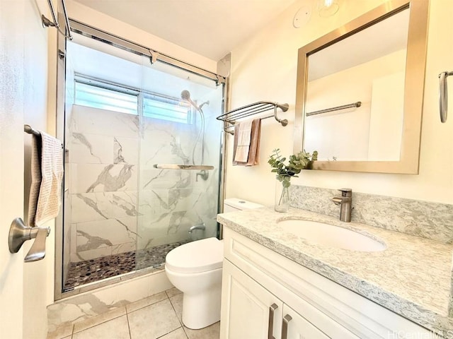 bathroom with toilet, vanity, a marble finish shower, and tile patterned floors