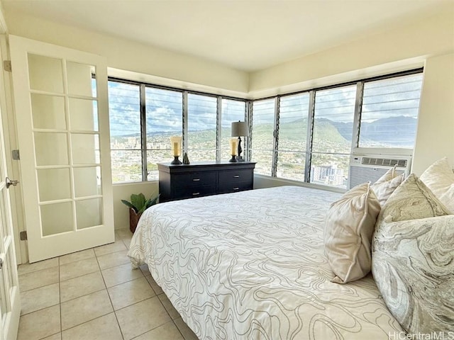 bedroom with cooling unit and light tile patterned flooring