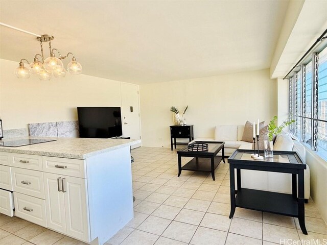 kitchen featuring light tile patterned floors, black electric stovetop, white cabinets, open floor plan, and light countertops