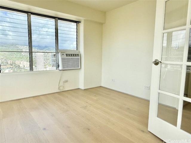 unfurnished room with cooling unit and wood finished floors