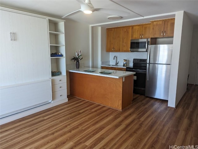 kitchen featuring sink, ceiling fan, appliances with stainless steel finishes, dark hardwood / wood-style flooring, and kitchen peninsula