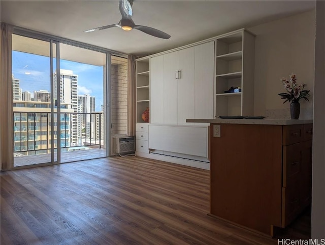 interior space with floor to ceiling windows, dark hardwood / wood-style flooring, an AC wall unit, and ceiling fan