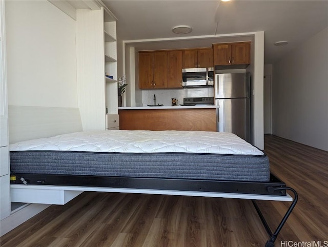 kitchen with kitchen peninsula, dark wood-type flooring, and appliances with stainless steel finishes