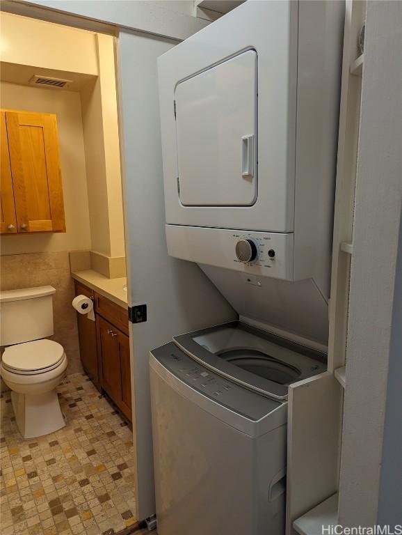 clothes washing area featuring stacked washer / drying machine