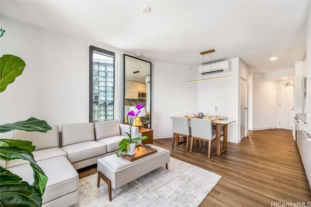 living room with hardwood / wood-style flooring and an AC wall unit