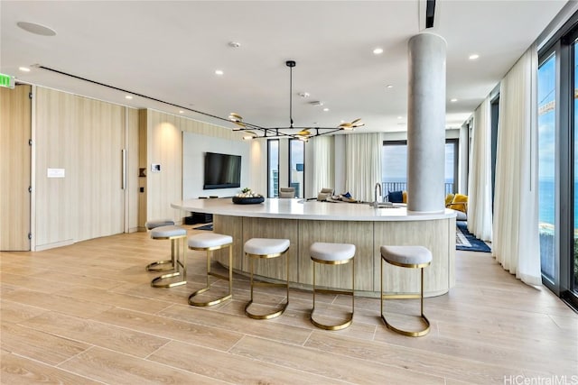 kitchen with a large island, a healthy amount of sunlight, and light hardwood / wood-style floors