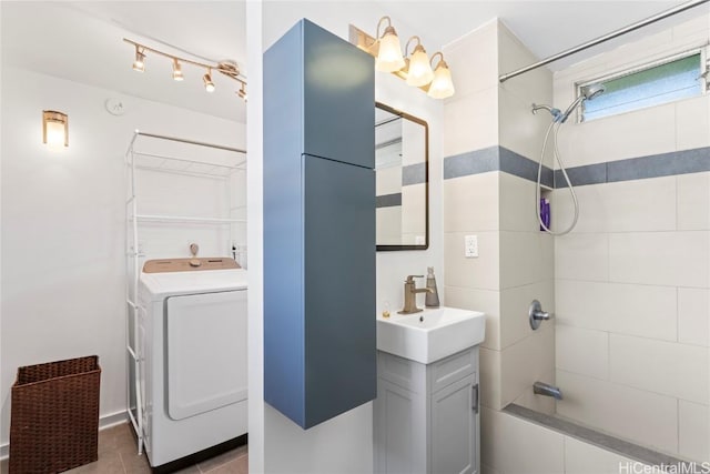 bathroom with washer / clothes dryer, tile patterned flooring, vanity, and tiled shower / bath