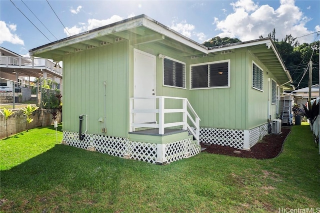 back of house featuring a lawn and cooling unit