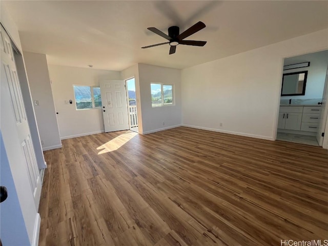 unfurnished living room featuring sink, hardwood / wood-style floors, and ceiling fan