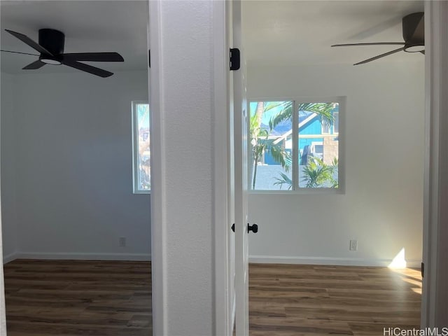 unfurnished room featuring dark hardwood / wood-style flooring, ceiling fan, and a healthy amount of sunlight