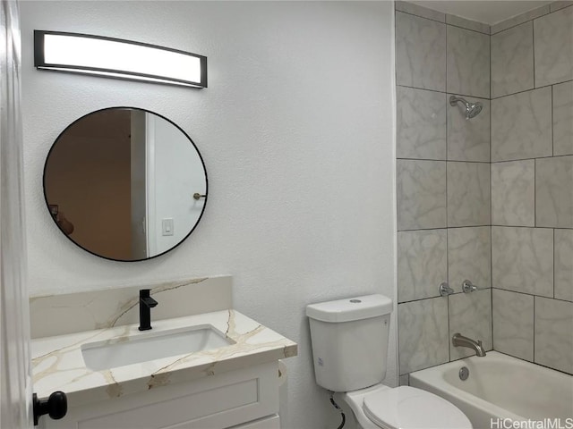 full bathroom with tiled shower / bath, vanity, and toilet