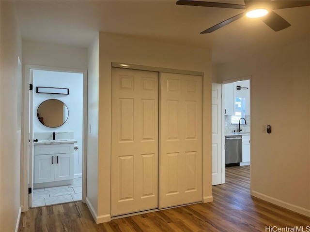 unfurnished bedroom with sink, hardwood / wood-style flooring, a closet, and ensuite bathroom