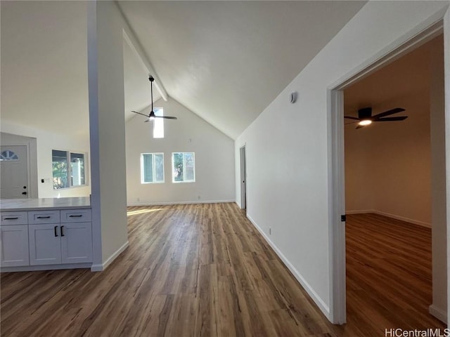 bonus room featuring dark wood-type flooring, ceiling fan, and lofted ceiling with beams