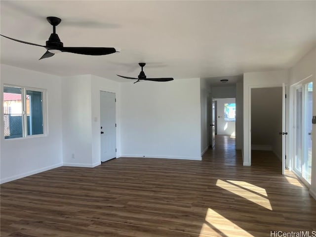 empty room with a wealth of natural light and dark hardwood / wood-style floors