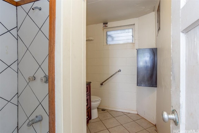 bathroom with tile patterned flooring, vanity, tile walls, and toilet