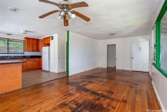 unfurnished living room featuring ceiling fan, light wood-type flooring, and sink