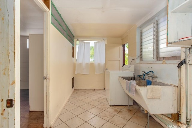 laundry area featuring washer / dryer, light tile patterned floors, and sink