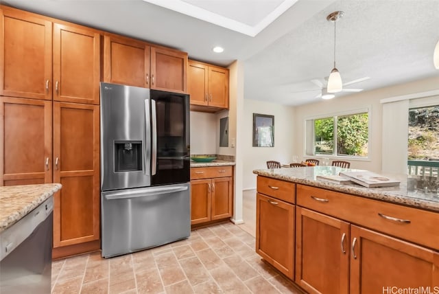 kitchen with ceiling fan, a textured ceiling, appliances with stainless steel finishes, decorative light fixtures, and light stone counters