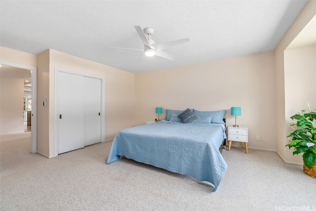 carpeted bedroom with ceiling fan and a textured ceiling