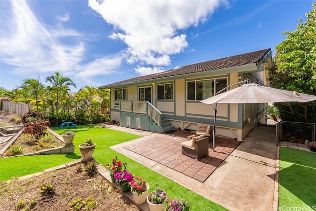 rear view of house featuring a yard and a patio area