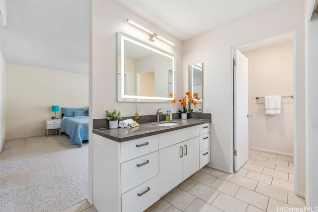 bathroom with tile patterned flooring, vanity, and a textured ceiling