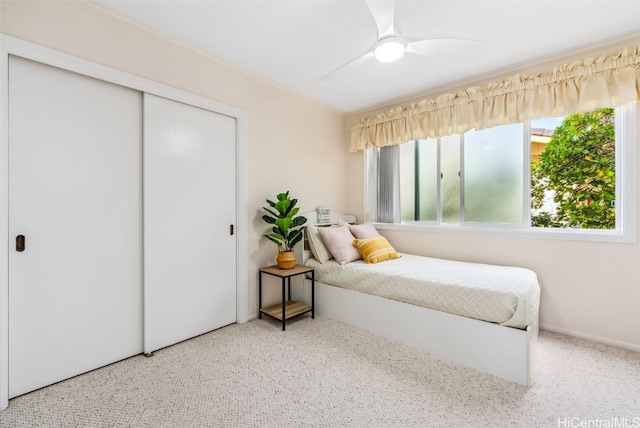 carpeted bedroom featuring a closet and ceiling fan