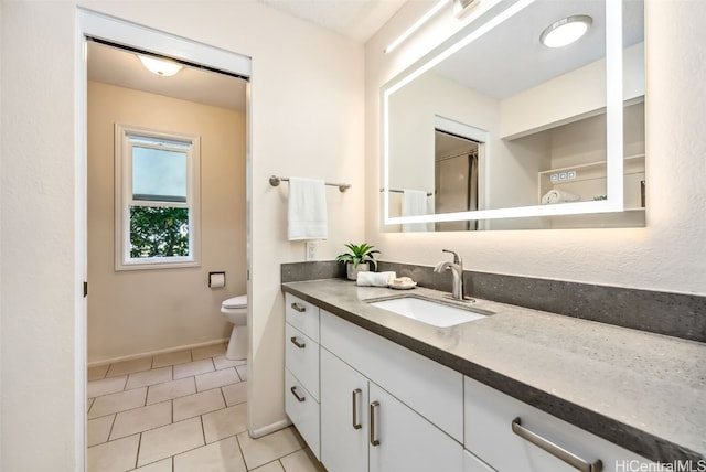 bathroom featuring tile patterned flooring, vanity, and toilet