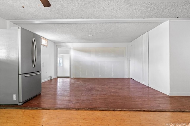 empty room featuring ceiling fan, wood-type flooring, and a textured ceiling