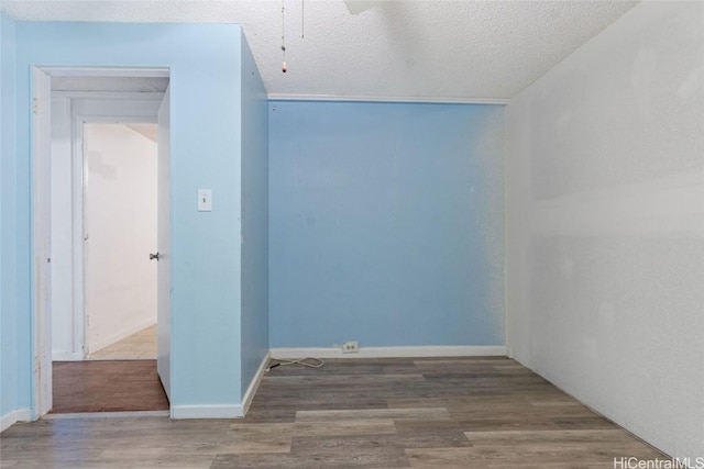 empty room featuring a textured ceiling and wood-type flooring