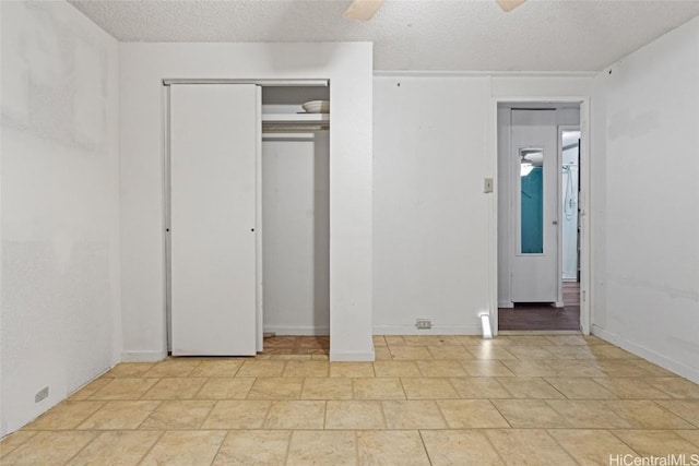 unfurnished bedroom with ceiling fan and a textured ceiling