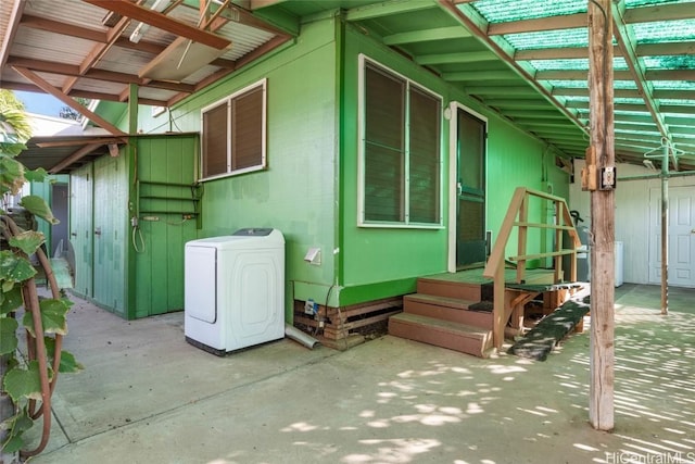 view of side of home with a patio area and washer / clothes dryer