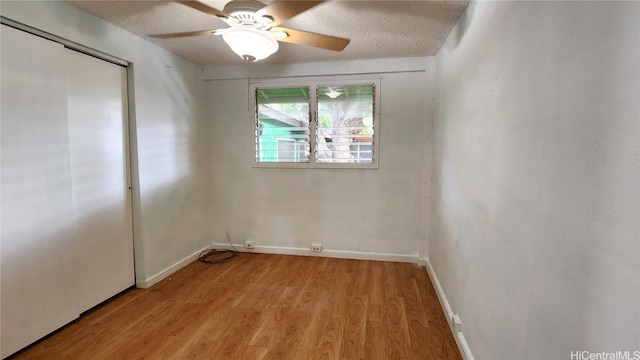 empty room featuring light wood-type flooring, ceiling fan, and a textured ceiling