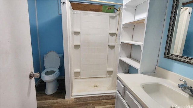 bathroom with walk in shower, vanity, toilet, and hardwood / wood-style floors