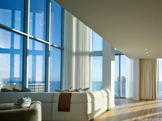 unfurnished living room with a healthy amount of sunlight, a water view, and light hardwood / wood-style floors