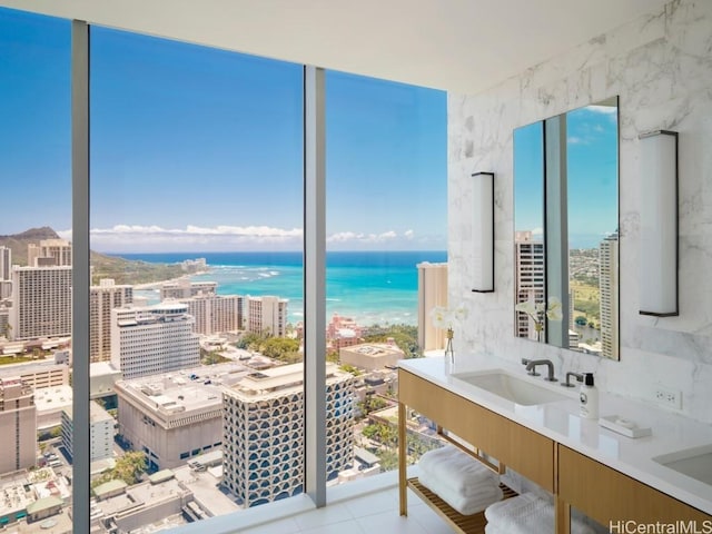 bathroom with tile patterned flooring, a healthy amount of sunlight, a water view, and sink