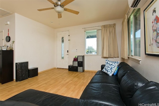 living room with hardwood / wood-style floors, ceiling fan, and a wall mounted air conditioner