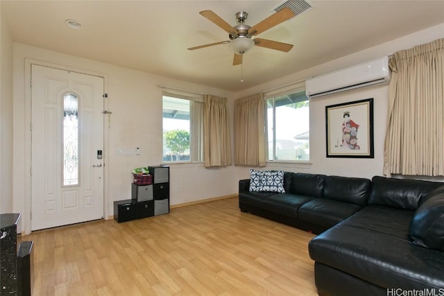 living room with light wood-type flooring, a wall mounted AC, and ceiling fan