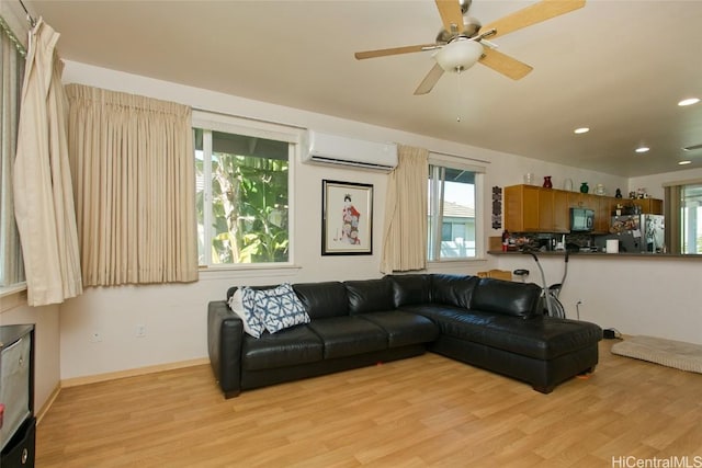 living room featuring light wood-type flooring, an AC wall unit, and ceiling fan