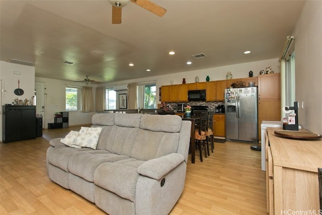 living room featuring ceiling fan and light wood-type flooring